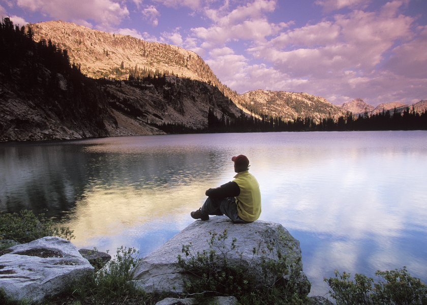Man sitting on a large rock.