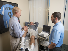 Provider works on man's knee on training table