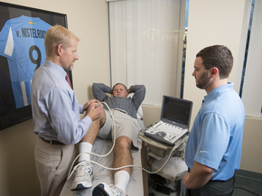 Provider works on man's knee on training table