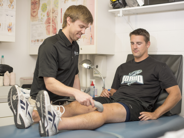 Provider helps an athlete stretch their leg