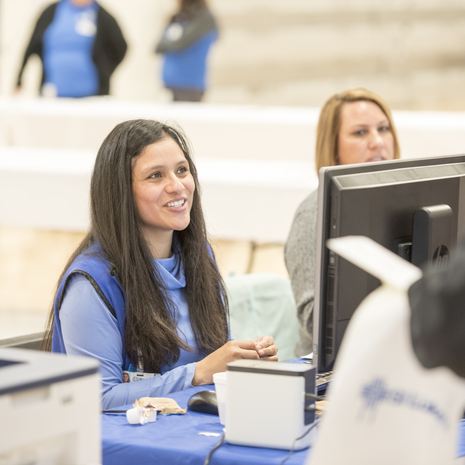 A St. Luke's staff member helping at the front desk.