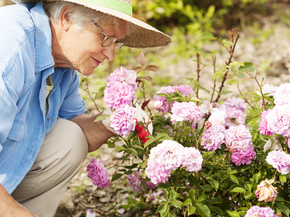 Woman smelling flowers in her garden