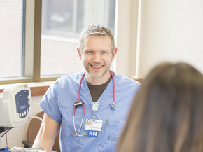 RN sitting at a computer.