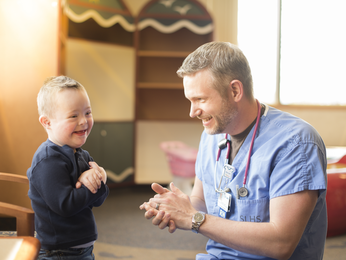 Registered nurse connecting with young patient through play.