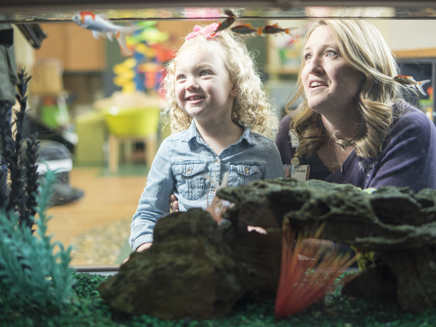 girl with child life specialist looking at fish tank