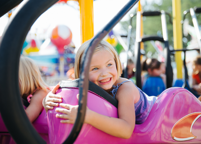 Girl smiles on carousel at Idaho state fair.