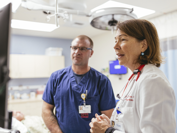 Physician and CNA looking at screen.