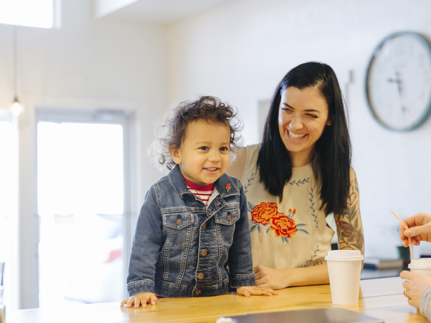 Young boy at counter smiles with his mother.