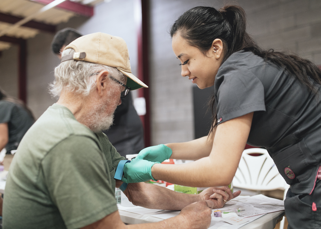 St. Luke’s provider helps patient during health fair.