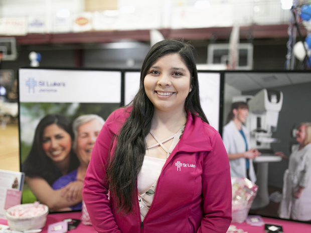 St. Luke's employee smiles at community health fair.