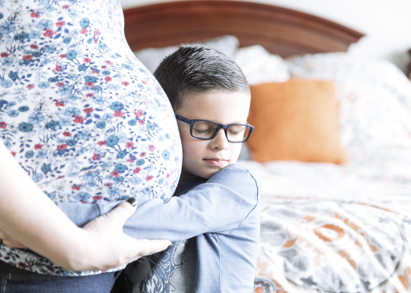 A young boy hugs his pregnant mother in a suite at St. Luke's Nampa