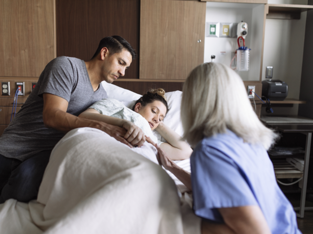 A pregnant woman holding her belly.