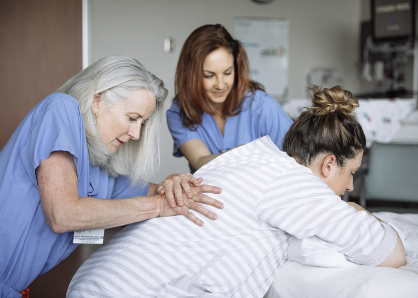 Nurses help a laboring mother