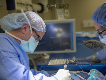 Neurosurgeon reviews x-rays on a screen.