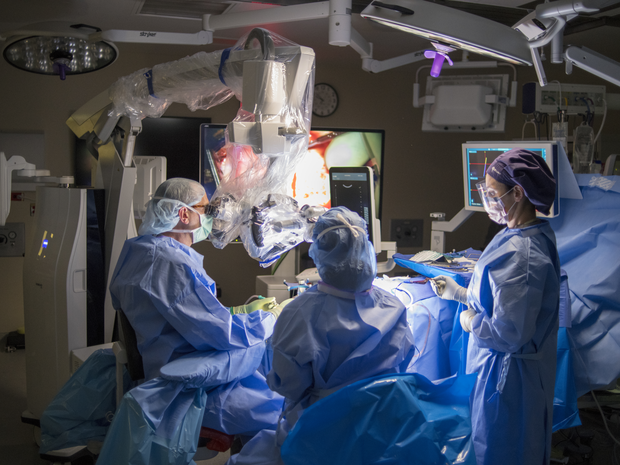 Two Neuroscience providers review x-rays on a large screen.