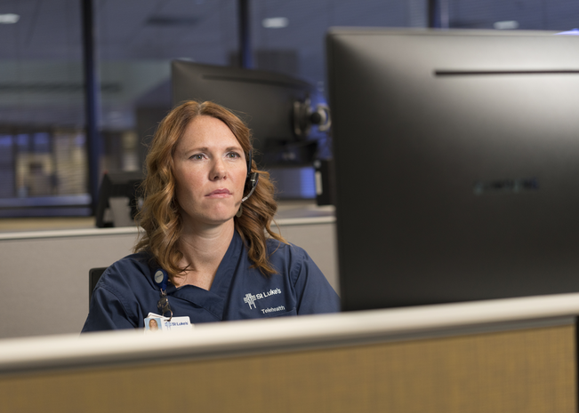 Woman working at desk of clinic.