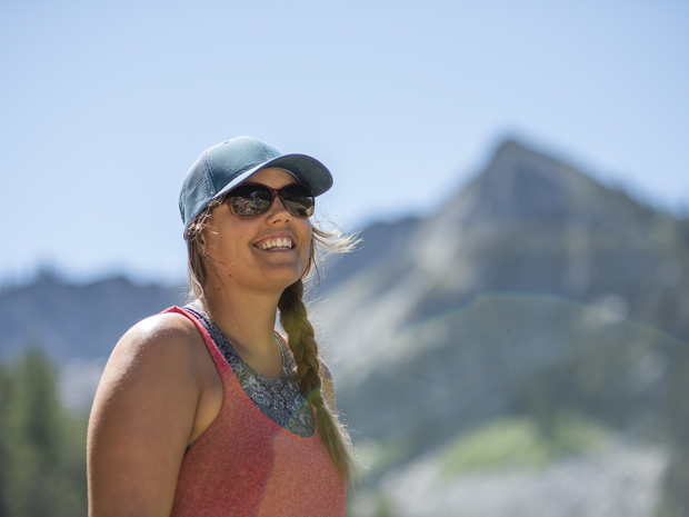 Woman smiles while hiking outdoors.