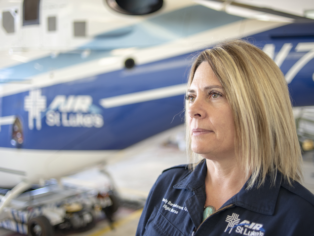 Female pilot in front of plane.