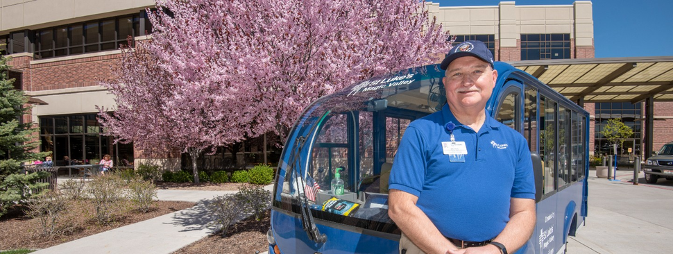 Driver standing in front a St. Luke's van.