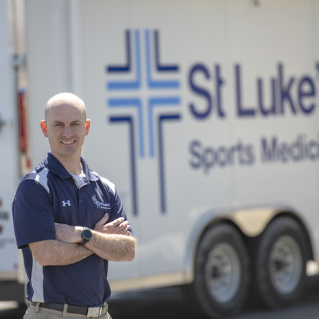 St. Luke's Sports Medicine physician with mobile medical support vehicle.