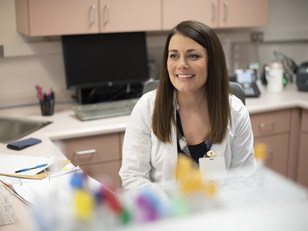 Lab service provider smiles in lab.