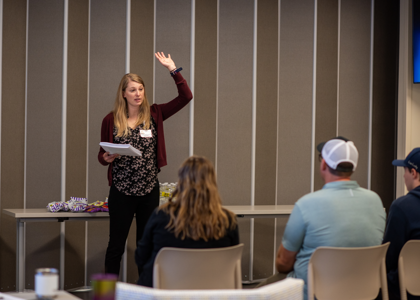  Woman with arm raised speaks to audience