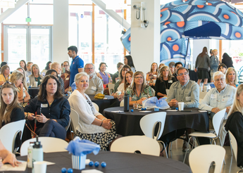 Attendees listen to a speaker at the celebration