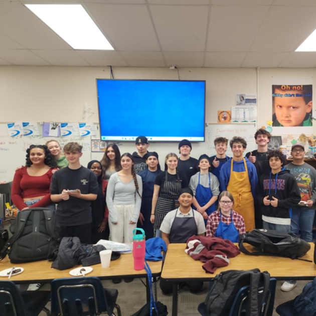  Group of culinary art students gathered in a classroom.