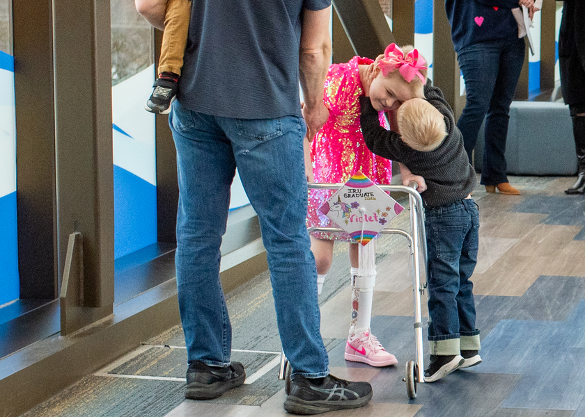 Little girl being hugged by her younger brother. 