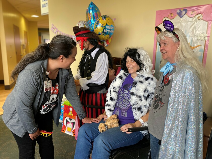 Four people dressed in Disney attire
