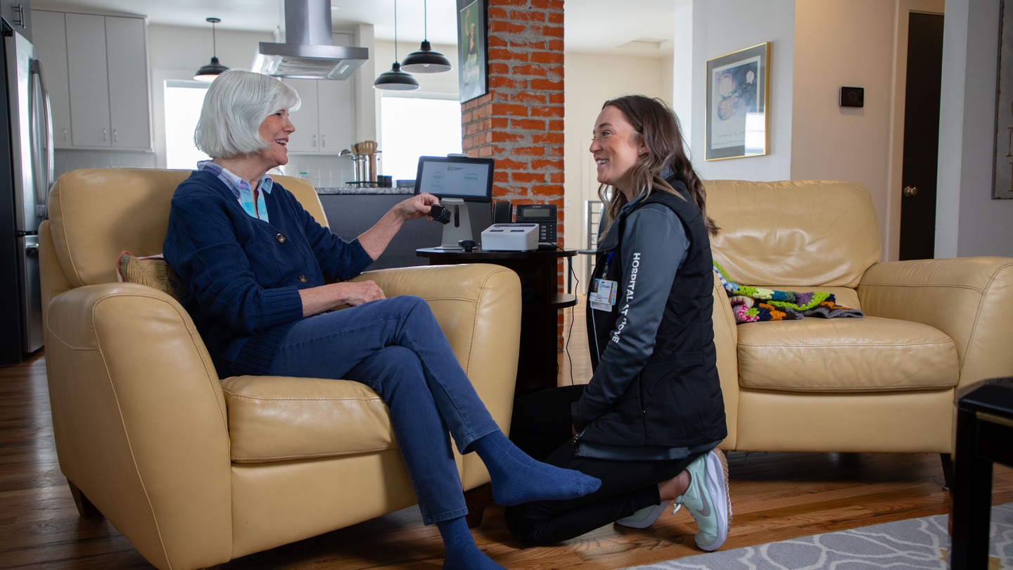 woman speaks with health care worker visiting her at home