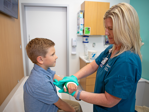 Orthopedic provider puts a cast on a young boy.