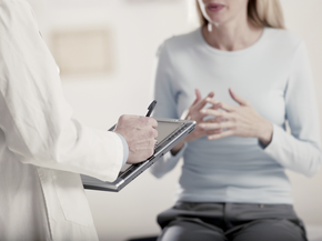 Woman discusses symptoms with doctor