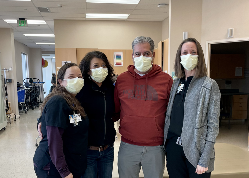 Four people in masks gather for photo