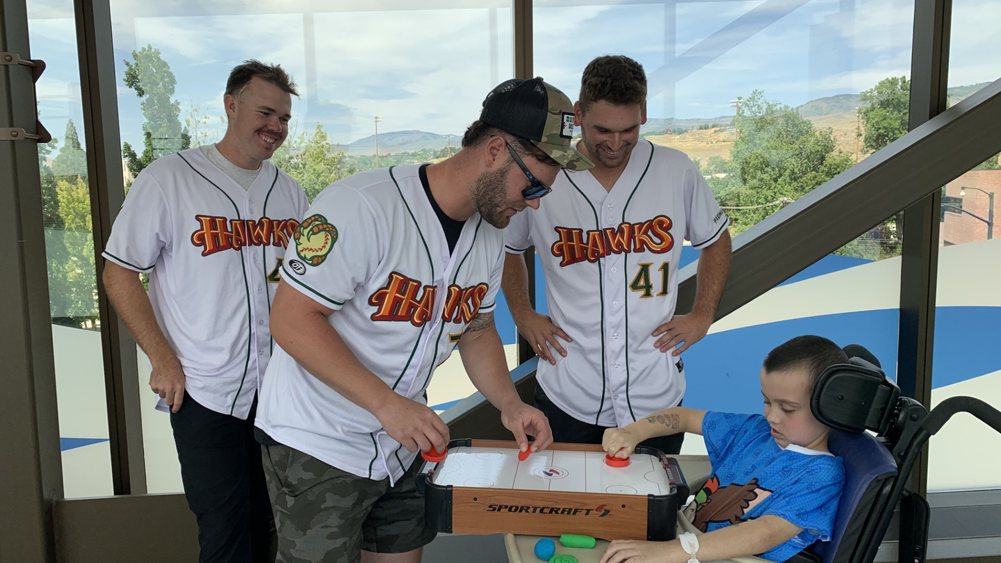  Baseball players play air hockey with patient