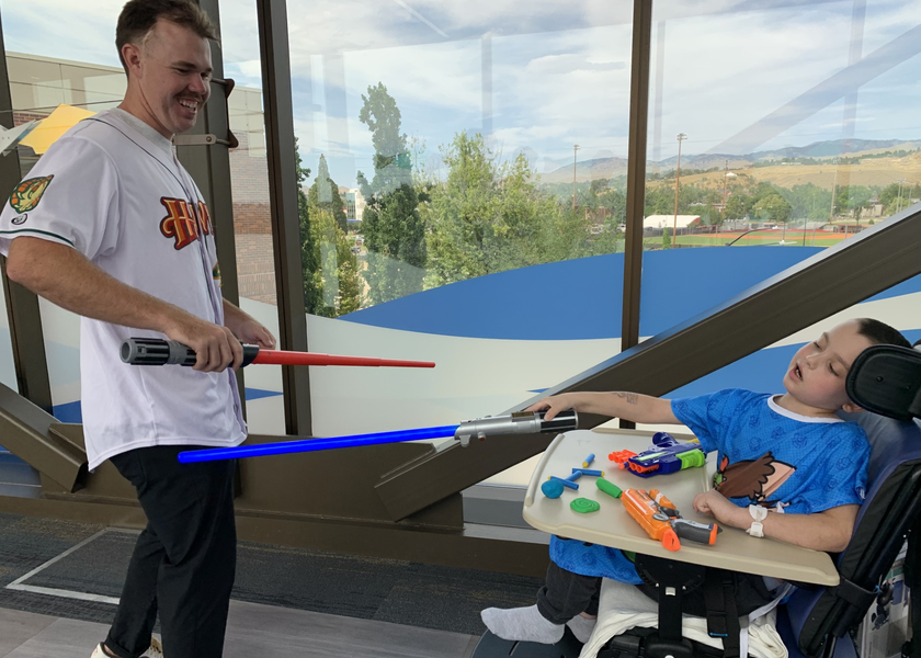  Young boy and baseball player due with lightsabers