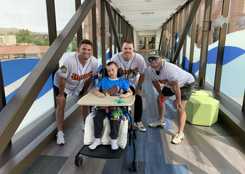 Young boy surrounded by baseball players