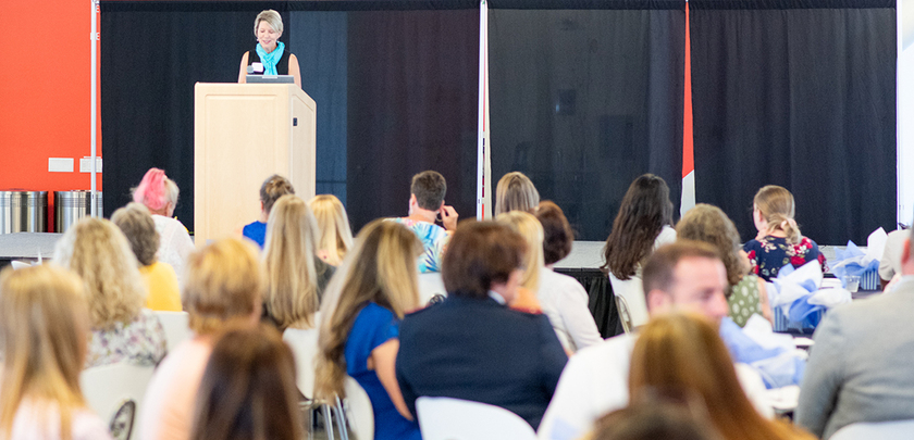 Speaker at podium in front of audience