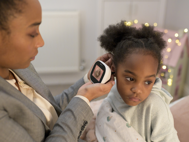 mom using TytoCare device to examine daughter’s ear