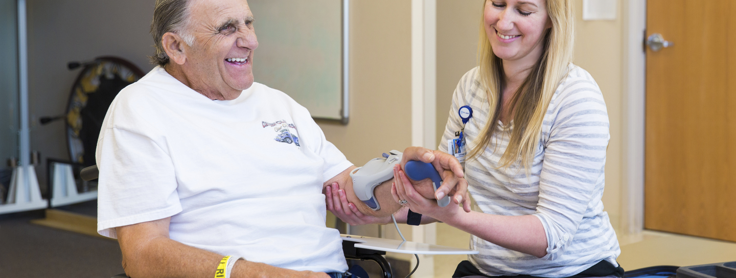 A man sitting in a wheelchair getting checked on by a nurse.
