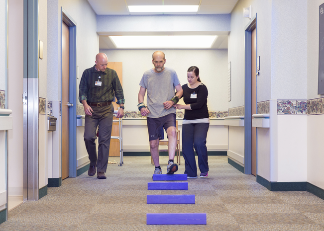 physical therapists help a patient through an excercise