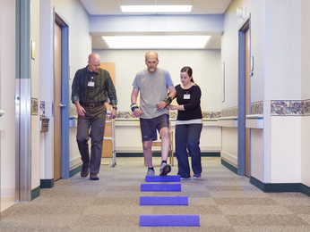 Man walking with support from providers.