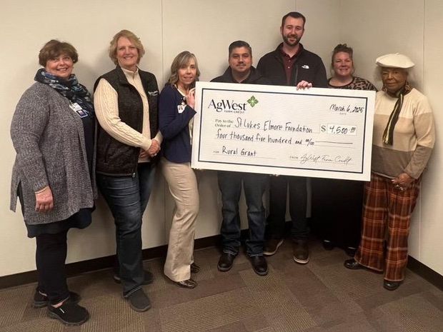 Employees hold up check donated.