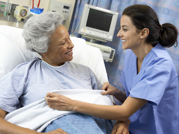 Nurse speaks to a patient in a hospital bed
