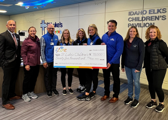 St. Luke's team members hold large FitOne check