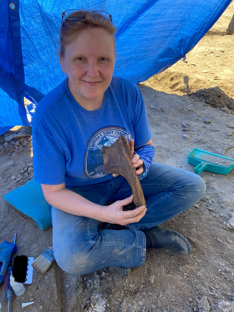  Woman under a tent holding a bone