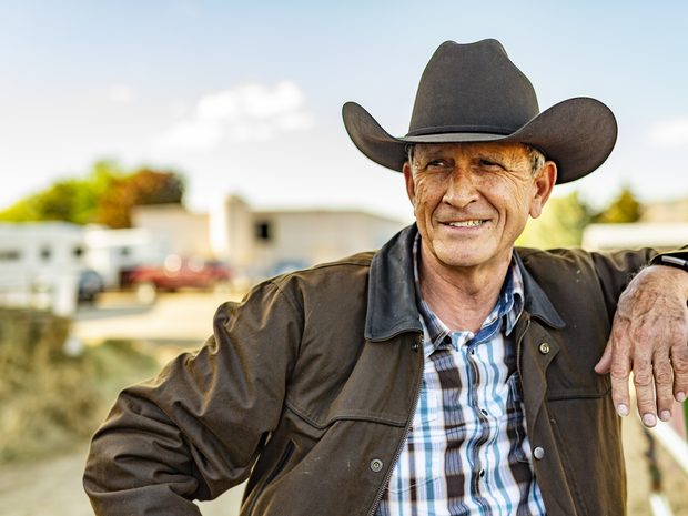 A man in a cowboy hat looks to the side
