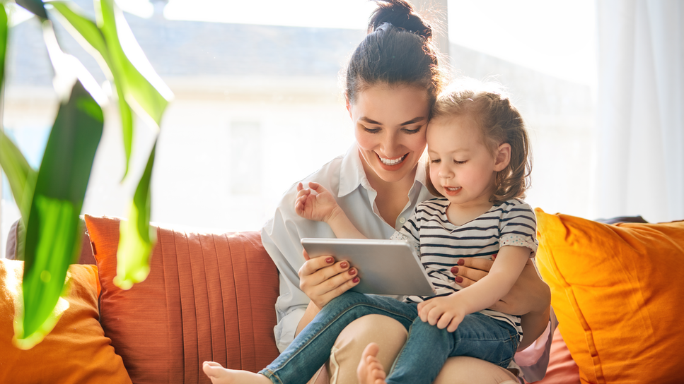 Mom with daughter on lap on virtual call.