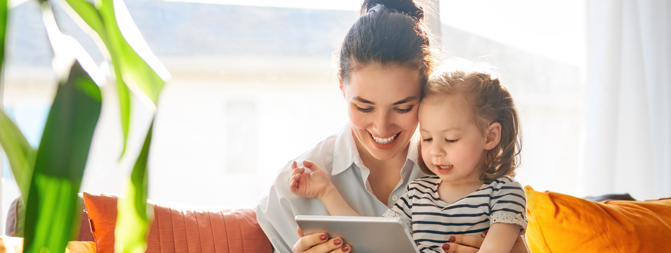 Mom with daughter on lap on virtual call.
