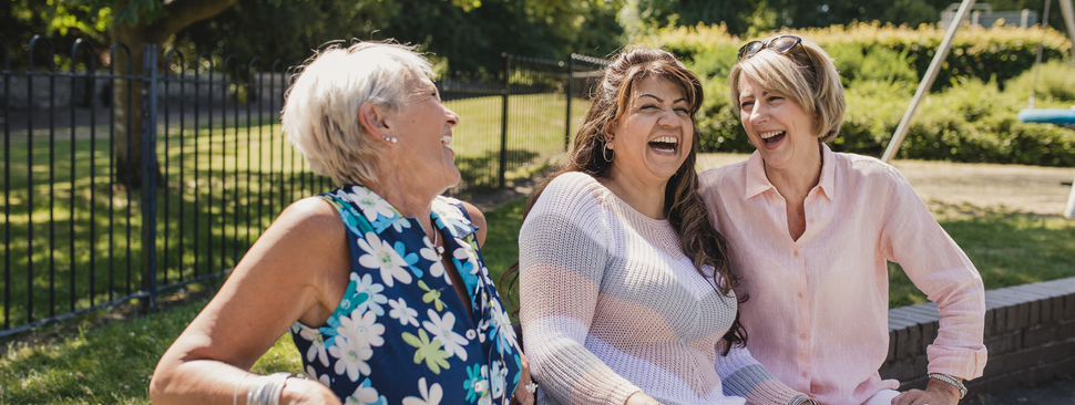 Women laughing on a park bench